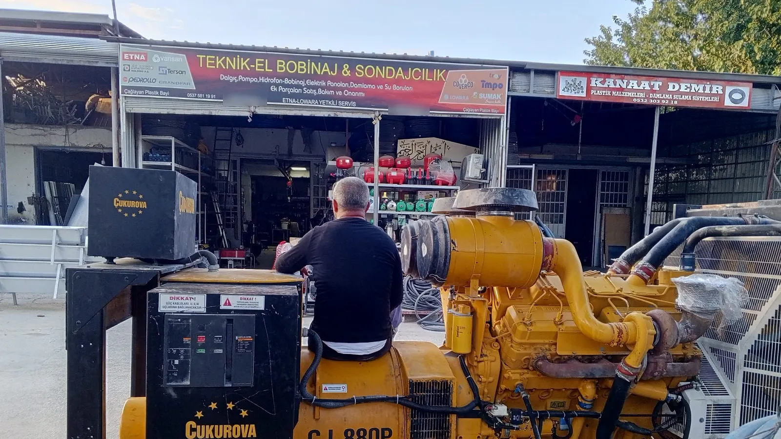 Teknik-El Bobinaj & Sondajcılık tabelalı dükkânın önü; Fatih BULUT büyük bir jeneratörün üzerinde çalışıyor